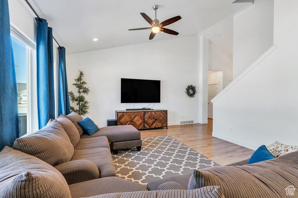 Living area featuring ceiling fan, wood finished floors, baseboards, recessed lighting, and high vaulted ceiling