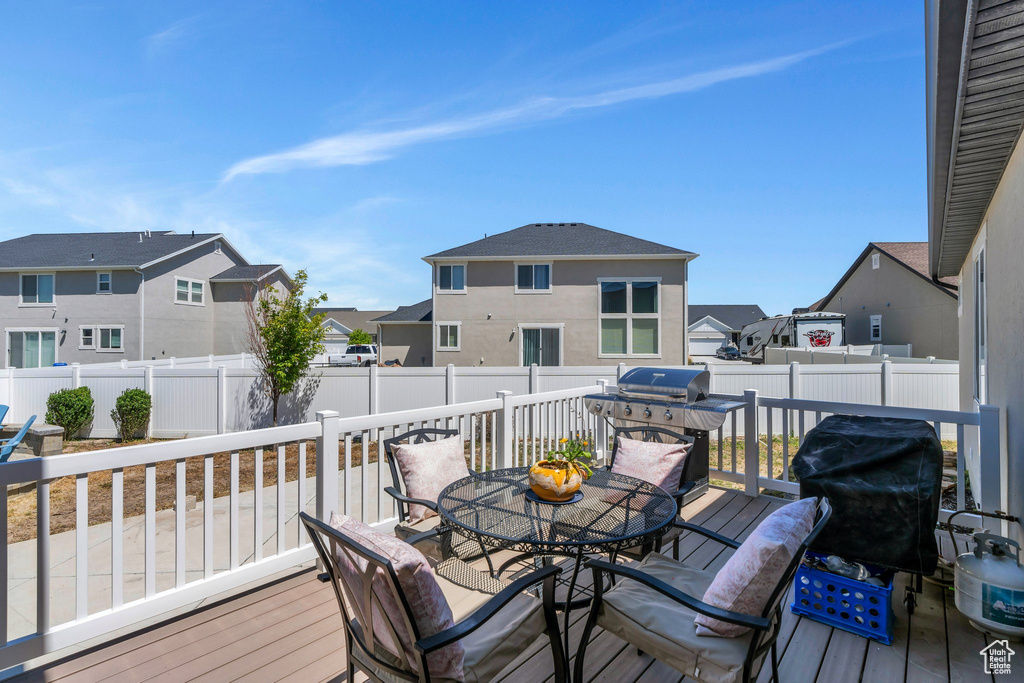 Deck featuring a residential view, a fenced backyard, grilling area, and outdoor dining space