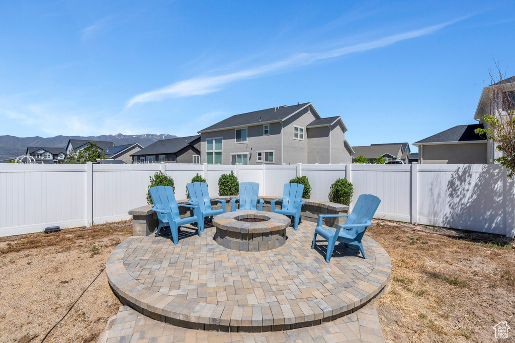 Fenced backyard with a patio area, an outdoor fire pit, and a residential view