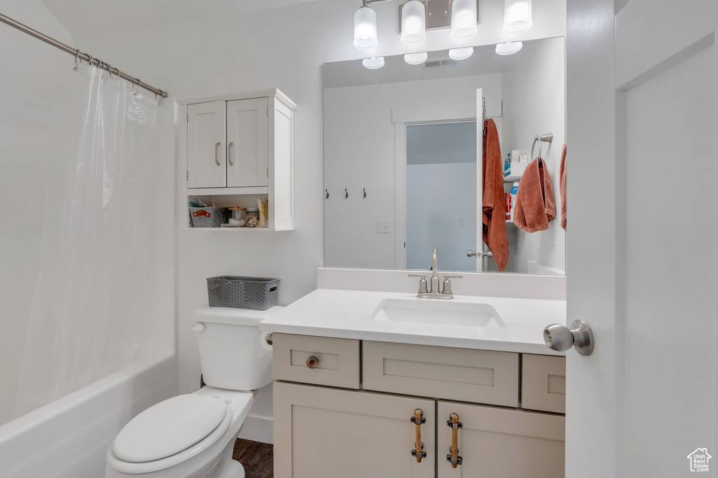 Bathroom with toilet, vanity, and shower / bath combo