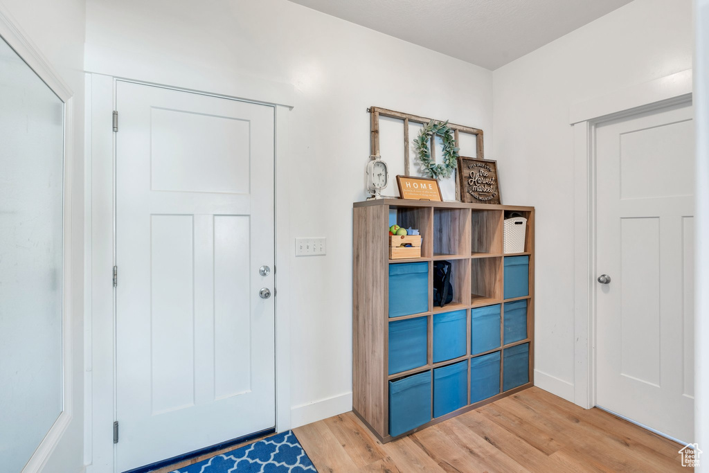 Foyer entrance featuring light wood-style flooring and baseboards