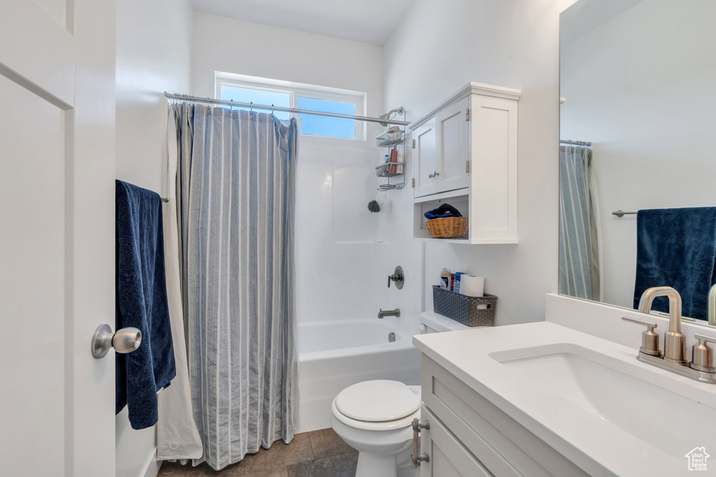 Bathroom with vanity, shower / bath combination with curtain, and toilet