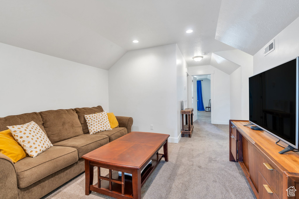 Living room with light carpet, lofted ceiling, recessed lighting, and baseboards