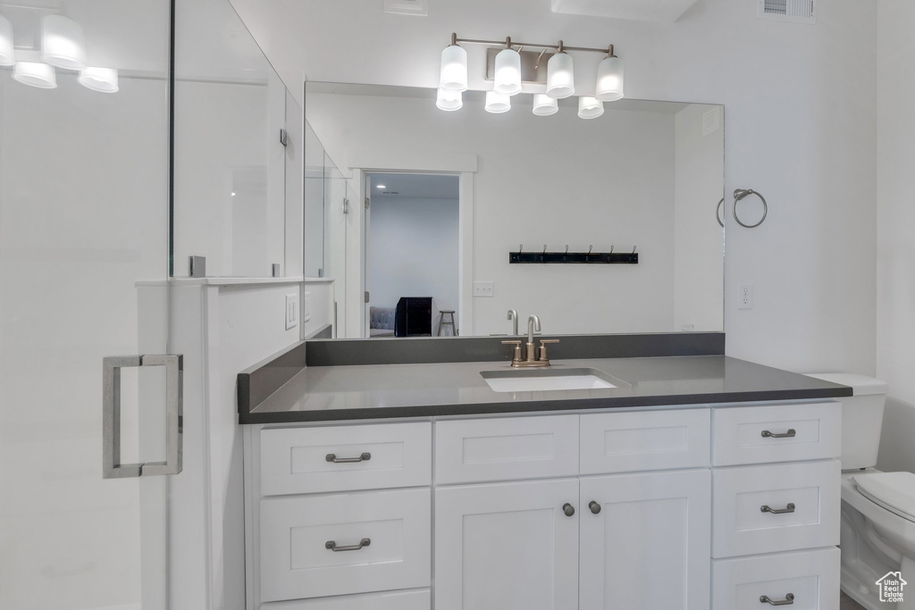 Bathroom with toilet, vanity, connected bathroom, and a shower
