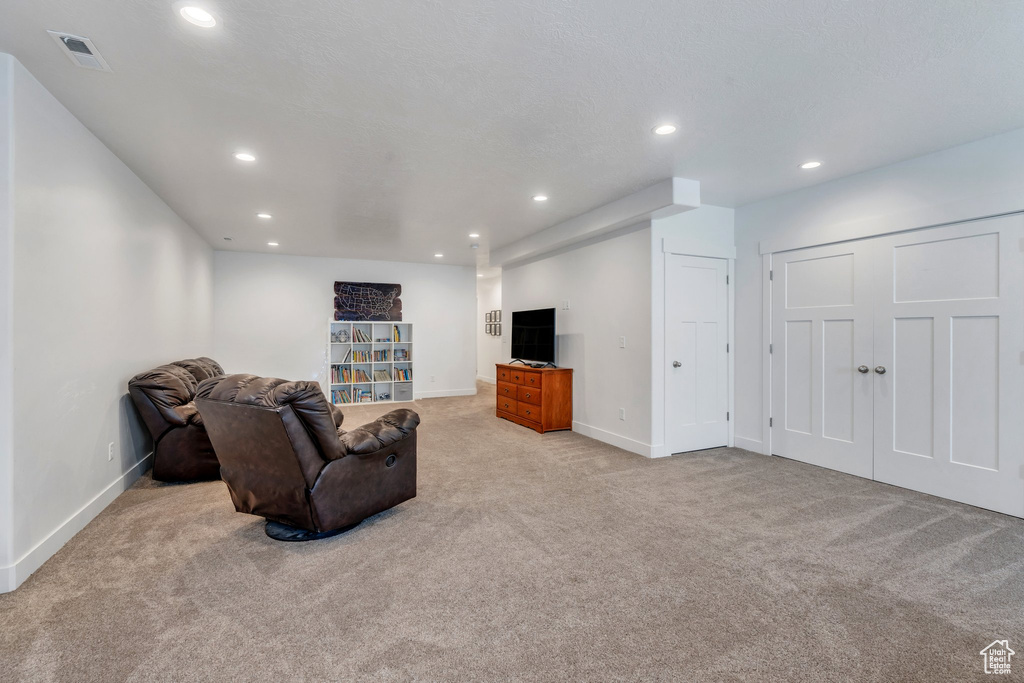 Carpeted living room featuring recessed lighting and baseboards