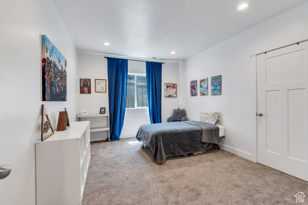 Bedroom with light colored carpet and recessed lighting
