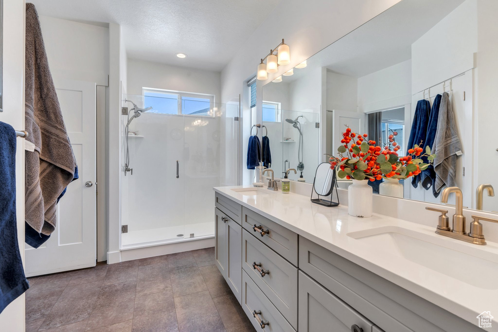 Full bathroom featuring a shower stall and double vanity
