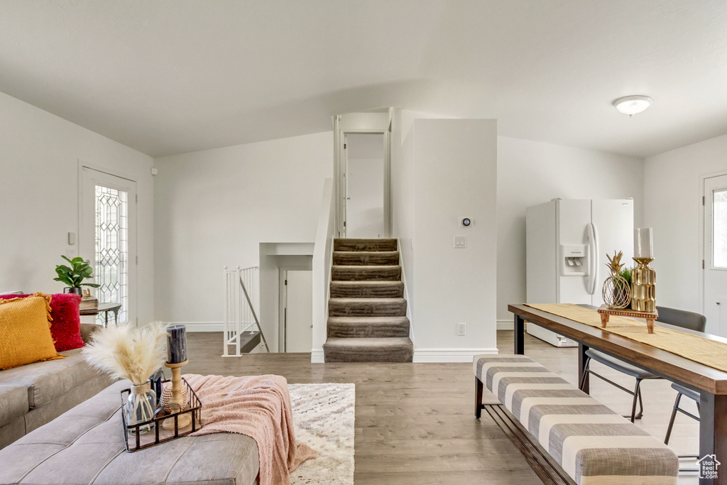 Living area featuring light wood-style floors, stairway, healthy amount of natural light, and baseboards