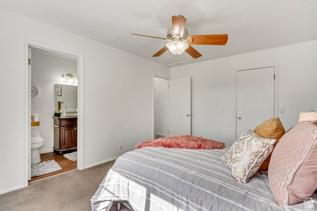 Bedroom with carpet floors, ensuite bathroom, a ceiling fan, and baseboards