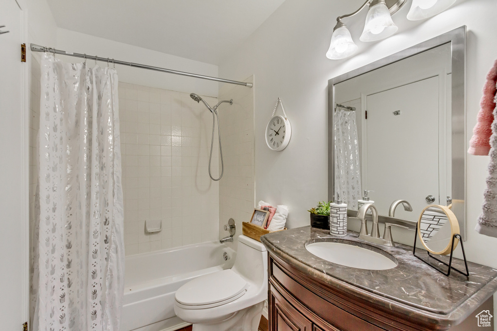 Full bathroom featuring vanity, shower / bath combo, and toilet