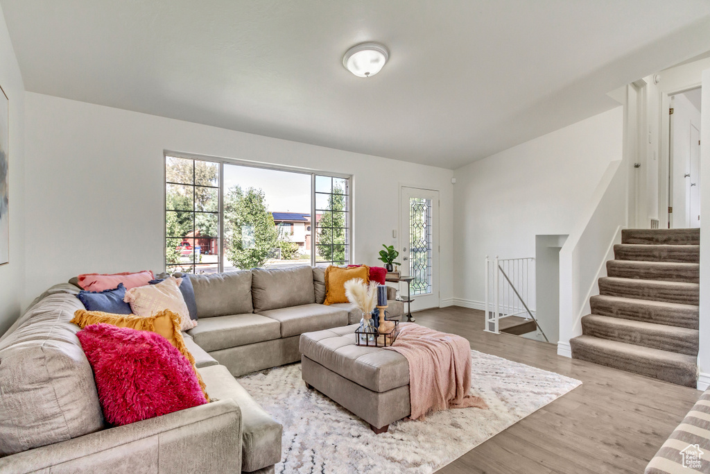 Living area featuring wood finished floors, stairway, and baseboards