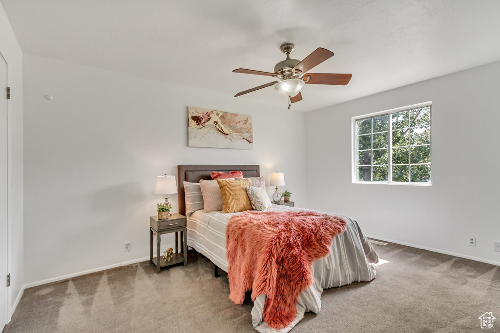 Carpeted bedroom with baseboards and ceiling fan
