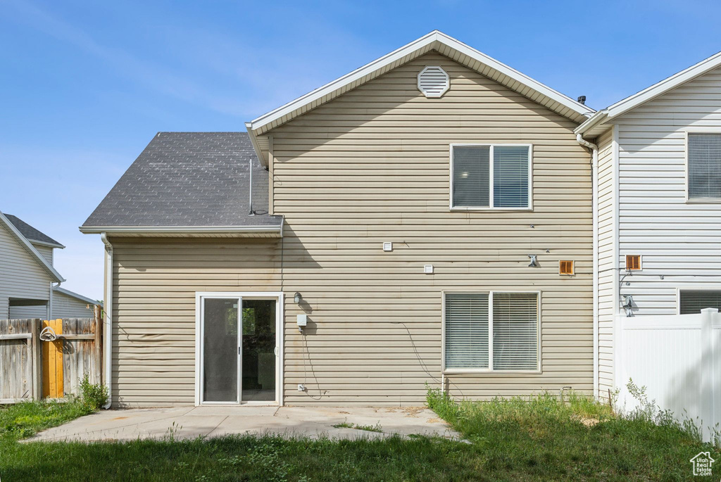 Rear view of property with a patio area and a shingled roof