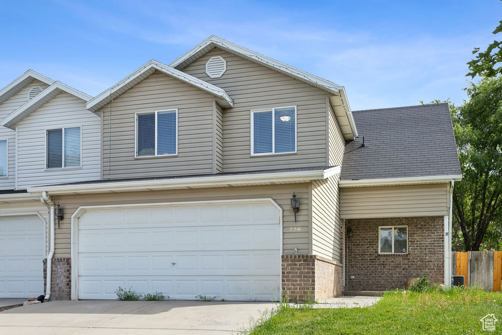 View of front facade with brick siding, an attached garage, and concrete driveway