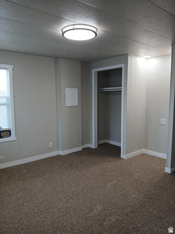 Unfurnished bedroom with carpet flooring, a closet, and baseboards