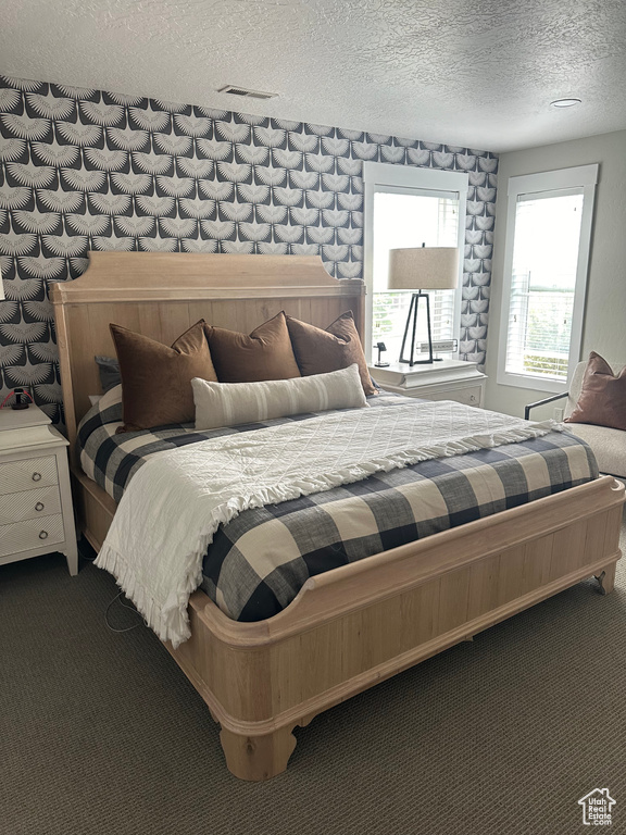 Bedroom featuring carpet and a textured ceiling
