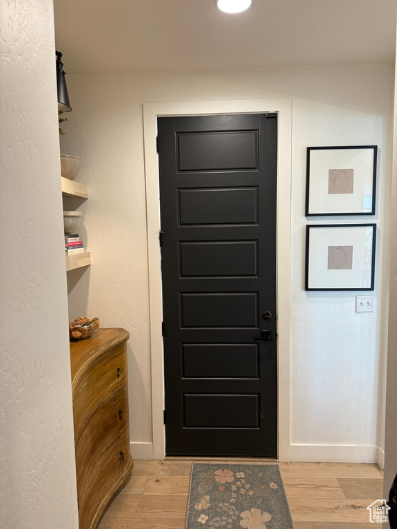 Doorway to outside with baseboards and light wood-style floors