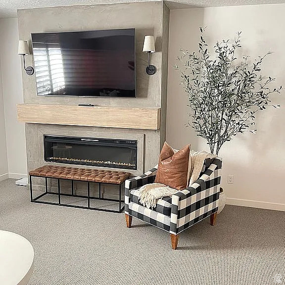 Sitting room featuring a glass covered fireplace, baseboards, and a textured ceiling