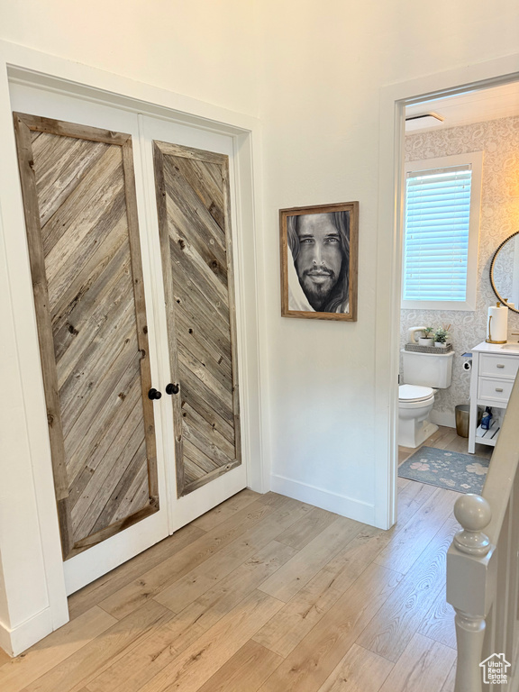 Hall with light wood-style flooring and baseboards