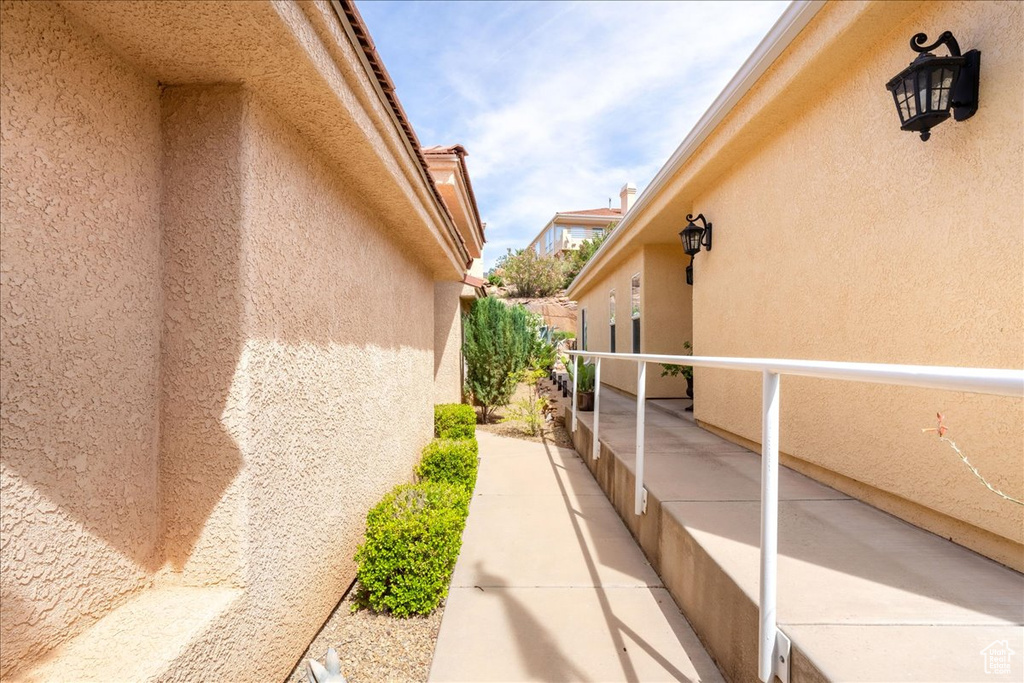 View of side of home with stucco siding and a balcony