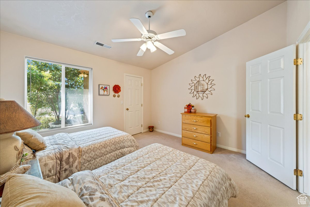 Bedroom featuring light carpet, lofted ceiling, baseboards, and ceiling fan