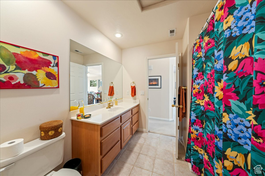 Bathroom with vanity, toilet, tile patterned flooring, baseboards, and curtained shower