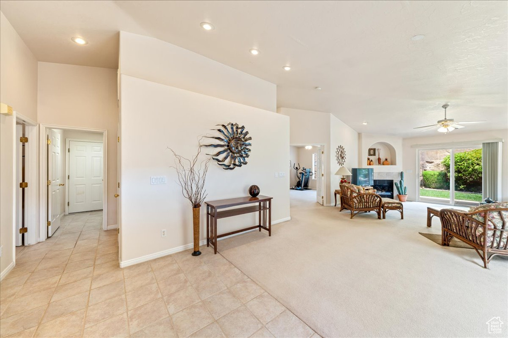 Living area featuring a tiled fireplace, recessed lighting, a ceiling fan, and baseboards