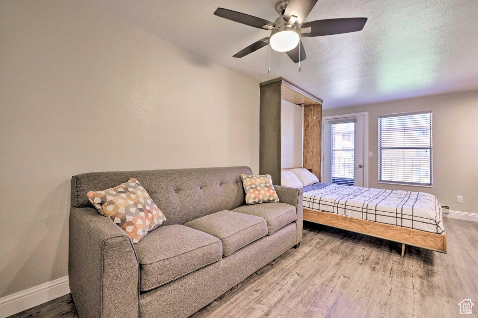 Bedroom featuring baseboards, wood finished floors, and ceiling fan