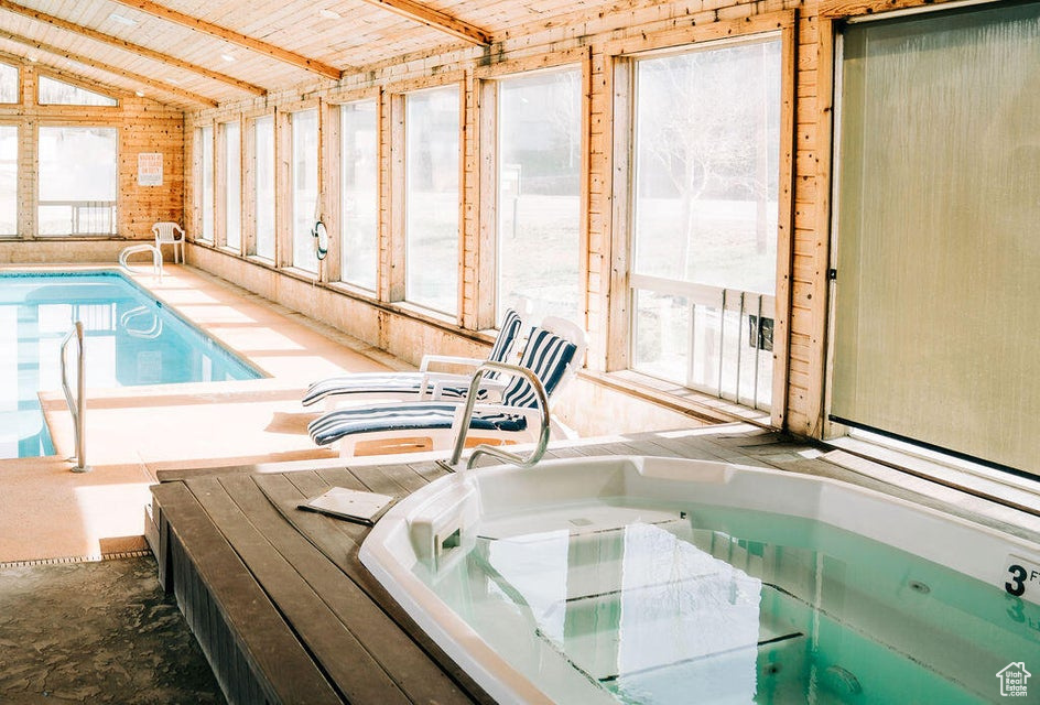 Indoor pool featuring an indoor hot tub