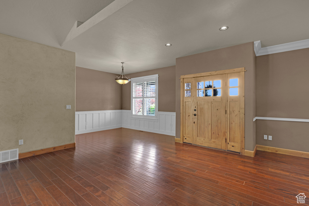 Entrance foyer featuring dark wood finished floors, a wainscoted wall, and recessed lighting