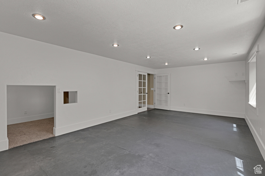 Spare room with concrete floors, recessed lighting, baseboards, and french doors
