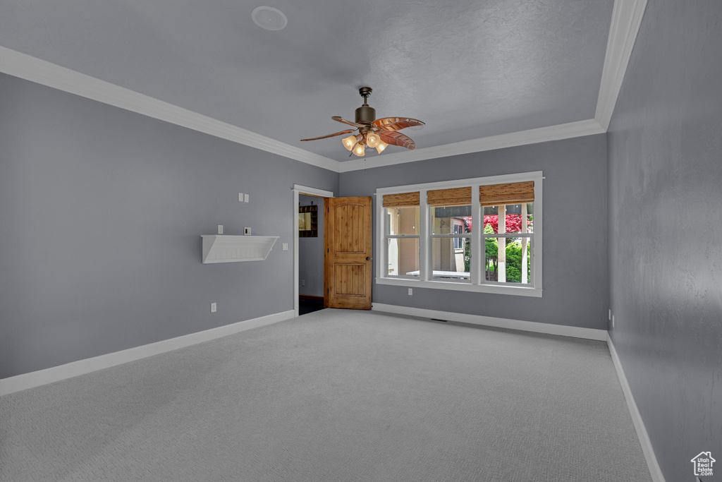 Unfurnished room with baseboards, ornamental molding, light carpet, and ceiling fan