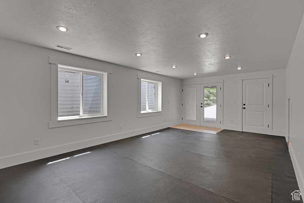 Entryway with baseboards, a textured ceiling, and recessed lighting