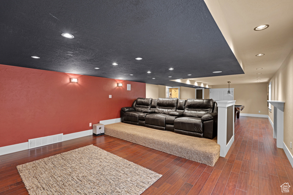 Home theater room featuring baseboards, wood finished floors, and recessed lighting