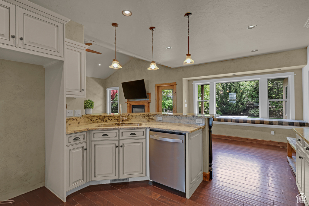 Kitchen with stainless steel dishwasher, dark wood finished floors, a sink, white cabinetry, and lofted ceiling