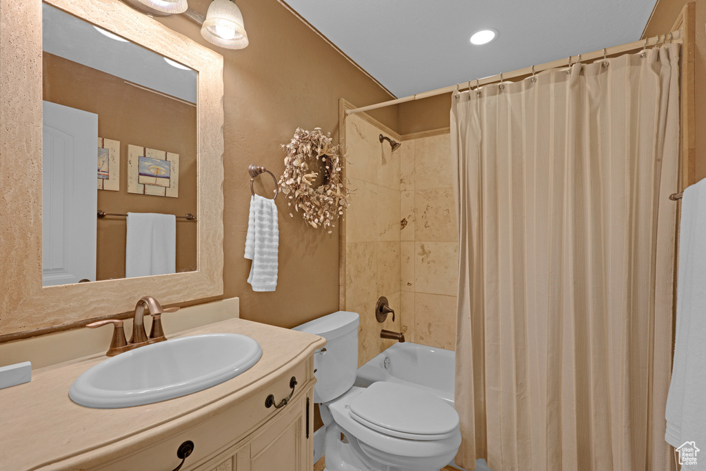 Full bathroom with toilet, vanity, shower / tub combo, and recessed lighting