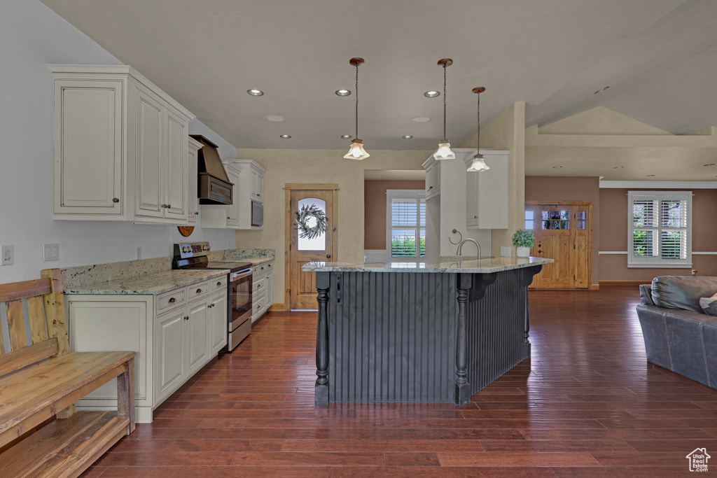 Kitchen with stainless steel range with electric stovetop, open floor plan, dark wood finished floors, light stone countertops, and white cabinets