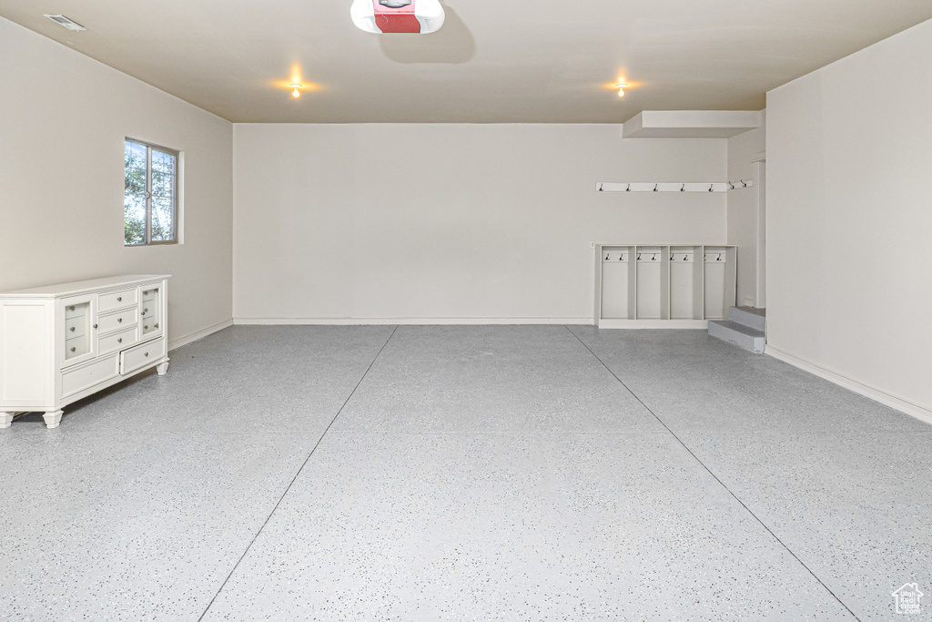 Garage with baseboards and a garage door opener