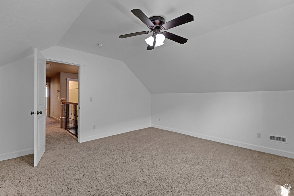 Additional living space featuring carpet flooring, lofted ceiling, baseboards, and ceiling fan