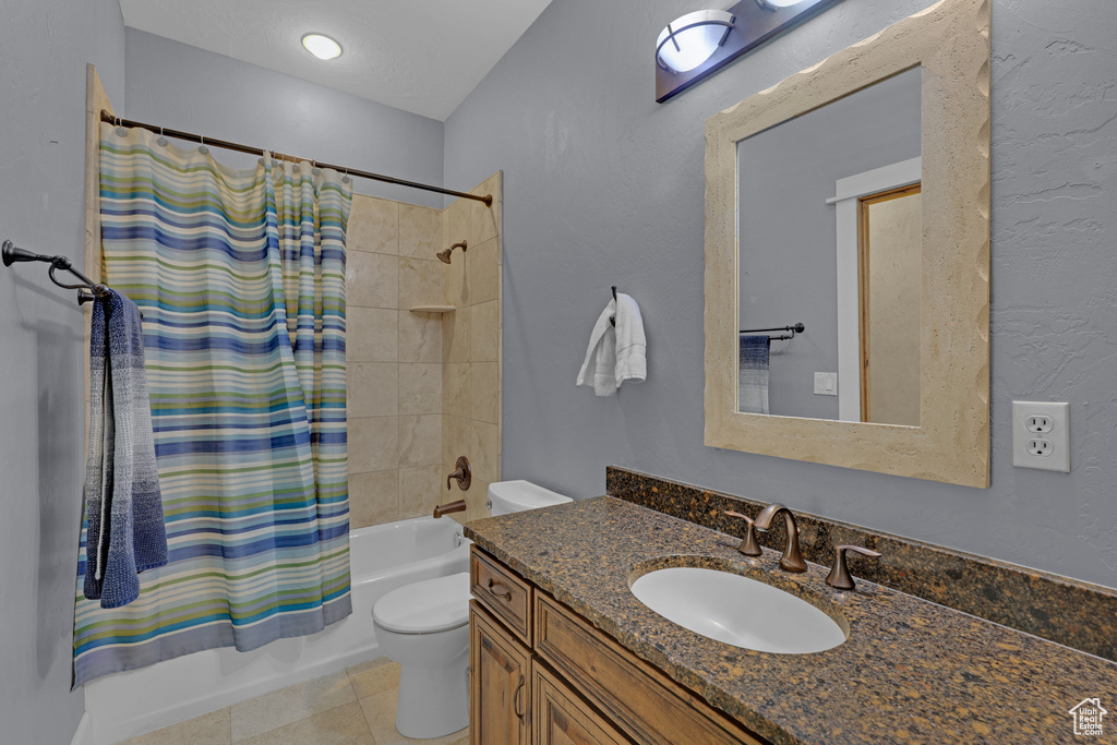 Bathroom with vanity, shower / bath combination with curtain, toilet, and tile patterned flooring