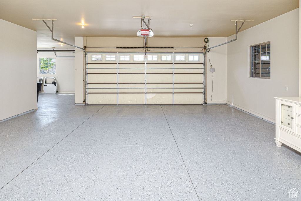Garage with a garage door opener and baseboards