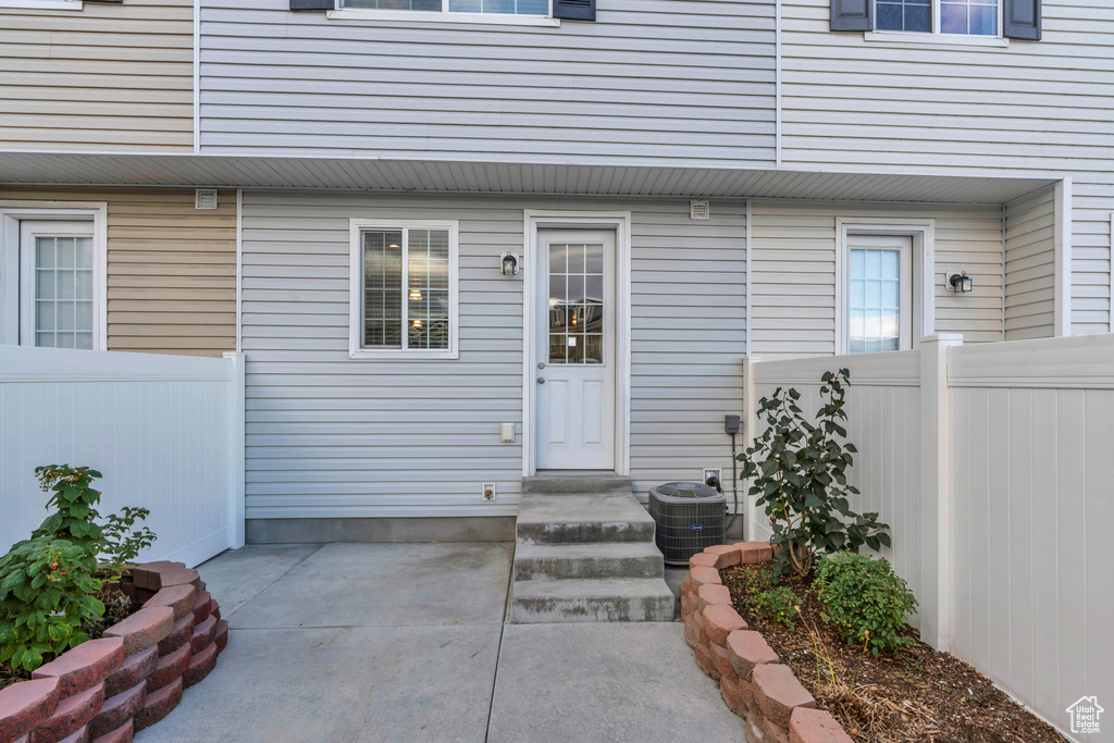 Entrance to property with cooling unit and a patio area