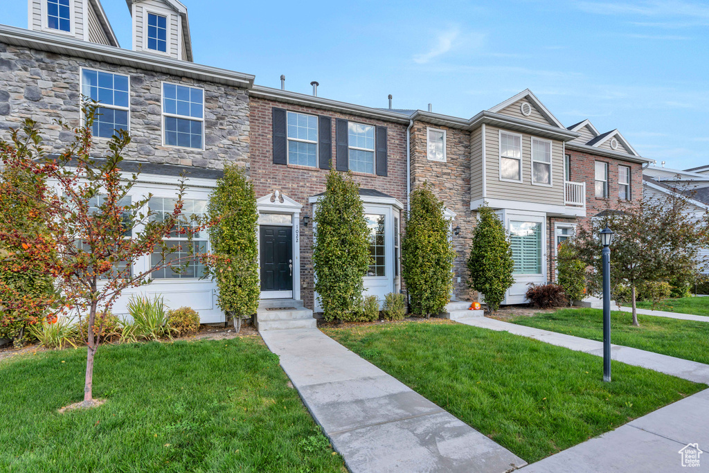 View of property with a front yard and entry steps