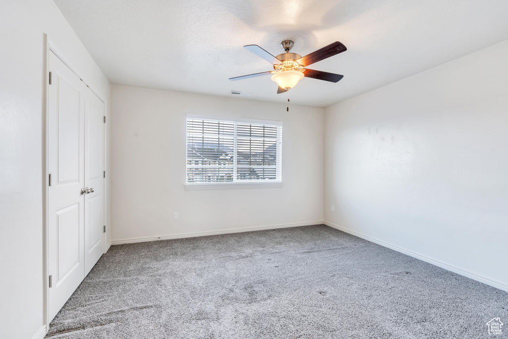 Unfurnished bedroom with carpet floors, ceiling fan, and baseboards