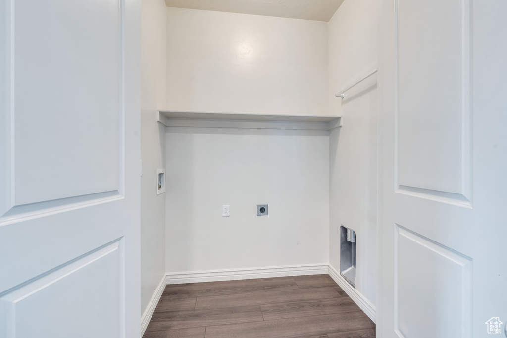 Washroom with electric dryer hookup, wood finished floors, washer hookup, and baseboards