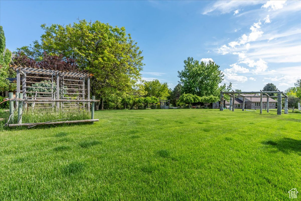 View of grassy yard with a pergola