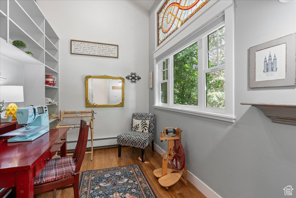 Office featuring healthy amount of natural light, wood finished floors, baseboards, and a baseboard radiator
