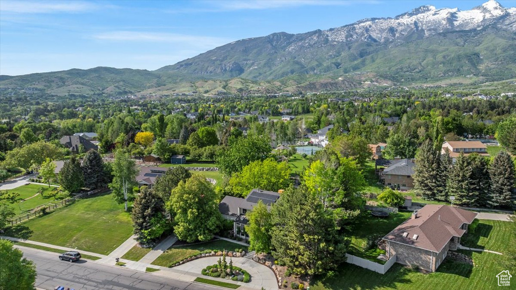 Aerial view of property and surrounding area featuring a mountain backdrop and nearby suburban area