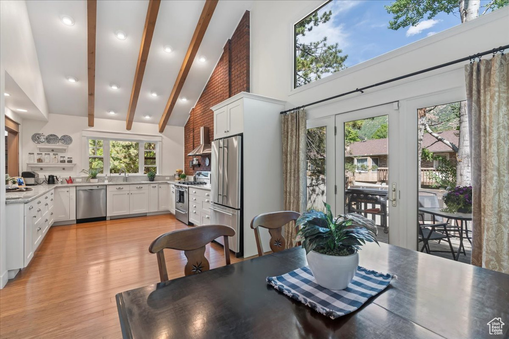 Dining area featuring beamed ceiling, high vaulted ceiling, light wood finished floors, french doors, and recessed lighting