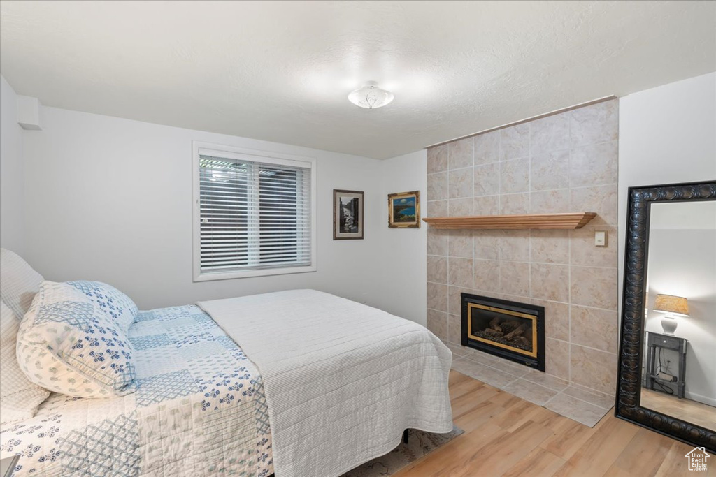 Bedroom featuring wood finished floors and a tile fireplace